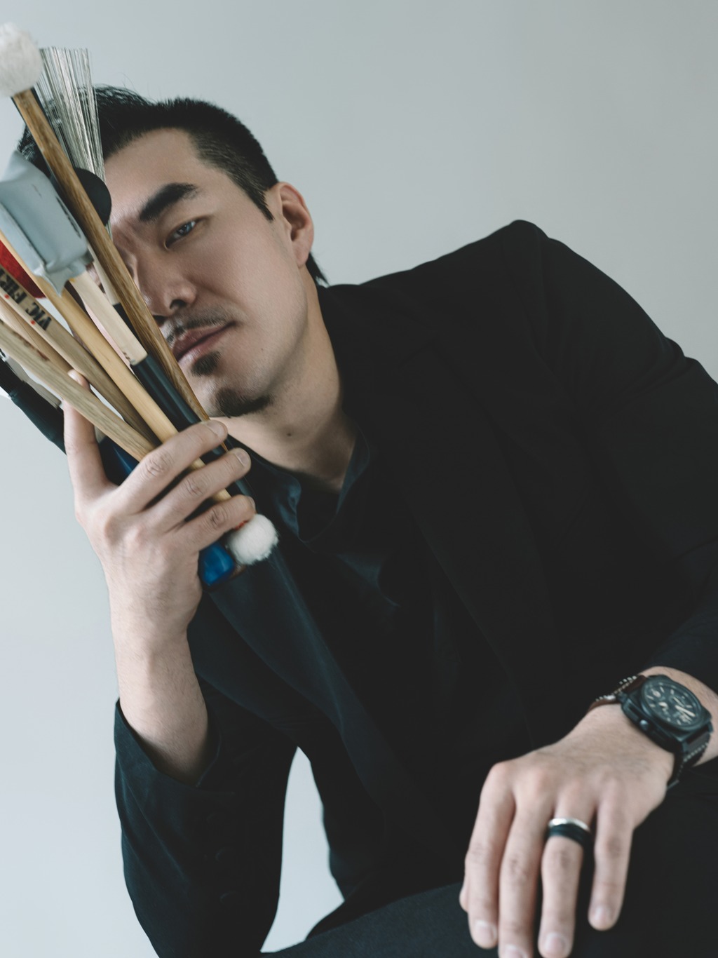 Color portrait of ZPZ holding percussion sticks and brushes